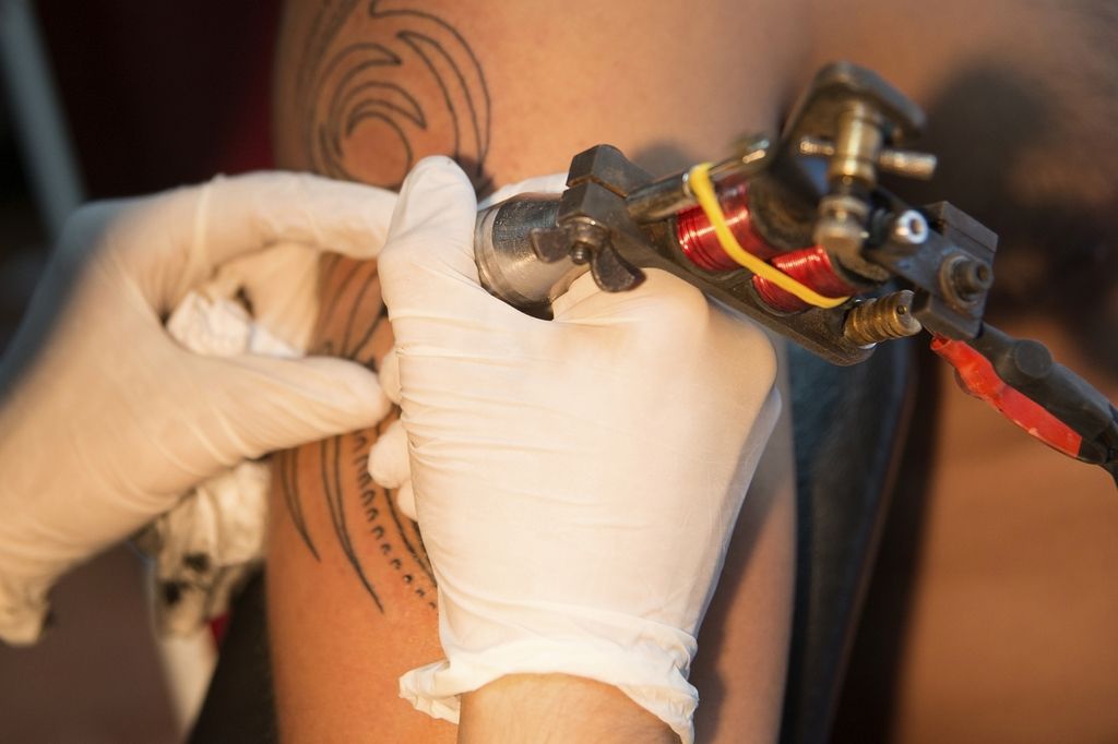  close up of a man's arm having its tattoo covered up