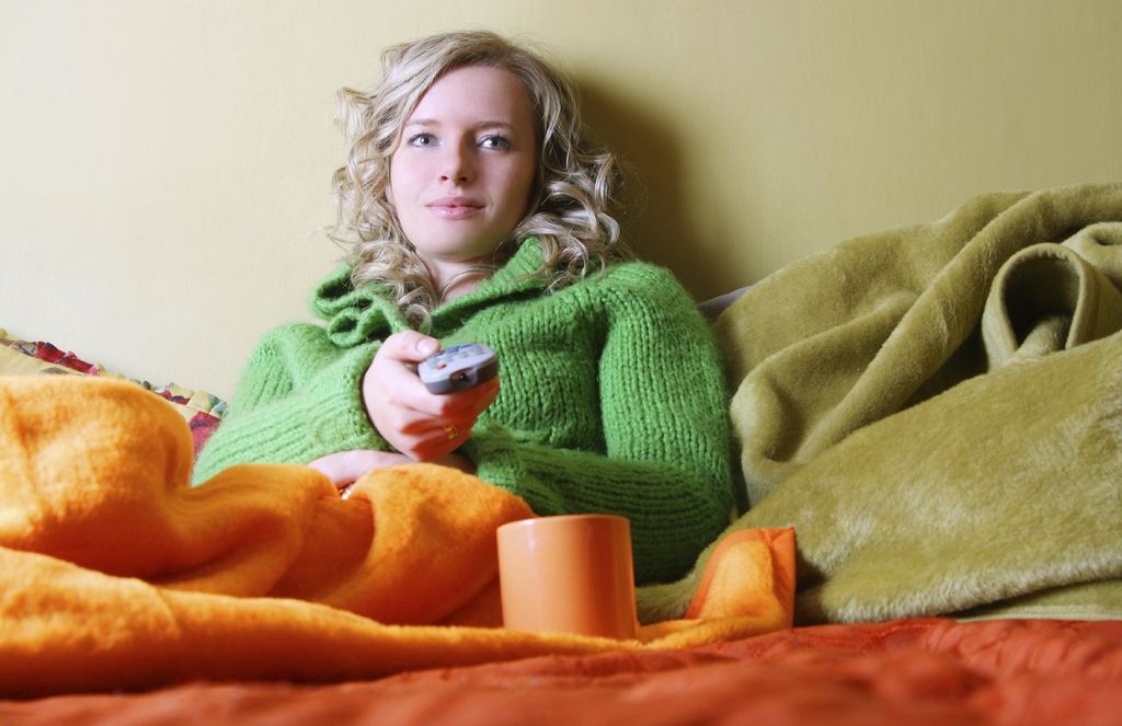 Woman Wrapped Up in Blanket Watching TV